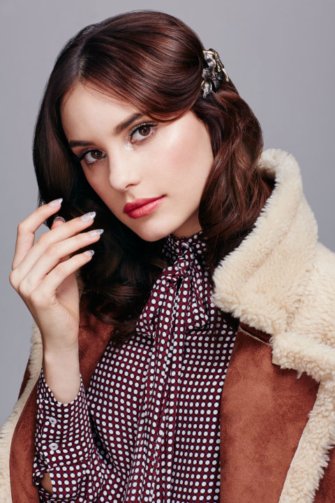 The '70s were alive and well on the runway at Jonathan Saunders, Balmain, and Alberta Ferretti for spring '16. To lend your holiday look some Studio 54 pizzazz, balance high-shine eyes and nails with a semi-matte mouth. Layer a metallic spice or copper lipstick (such as Maybelline New York Color Sensational Lip Color in Bronzed) under a "veil" of pink (like Maybelline New York Lip Studio Color Blur Matte Lip Pencil in I Like to Mauve It). "It's almost like toning your hair color," Anthony explains. "This approach leaves you with a multidimensional satin finish." To apply glitter to eyes minus major fallout, warm up a clear lip balm between your thumb and forefinger, dab it across lids, and use your pointer finger to pick up the shiny particles and tap them in place. Anthony applied a chunky glitter first (try MAC Glitter in 3D Silver), followed by a finer blend (such as Make Up For Ever Glitter in Silver) to "fill in any gaps."
Blouse: Zara; Coat: ASOS